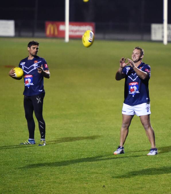 PREPARATION: Daniel Tung , left, and Shane Hutchinson, who is a late inclusion in the Ballarat line-up, warm up at training at Wendouree on Thursday night. Picture: Kate Healy