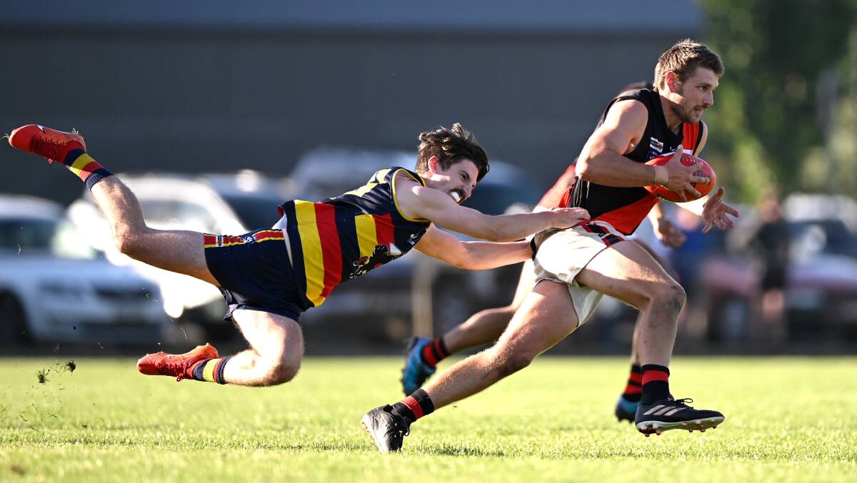 Beaufort's Flynn Kellett makes a flying tackle at full stretch on Lachie Burbidge (Buninyong) at Beaufort, Picture Adam Trafford.