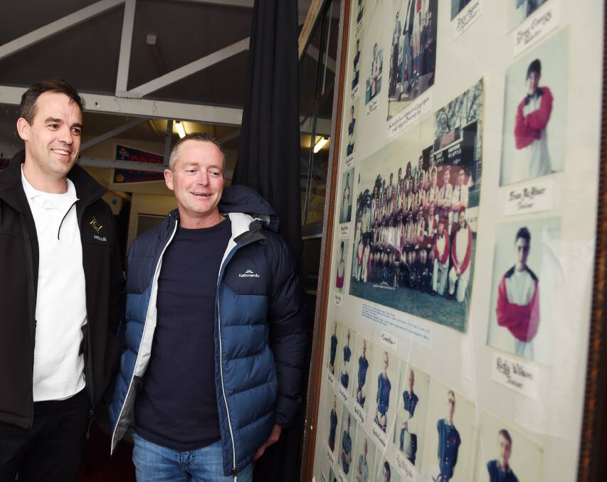 East Ballarat 1993 premiership players Peter Jacks and Scott O'Donohue admire team and player photographs from that famous season ahead of Saturday's reunion