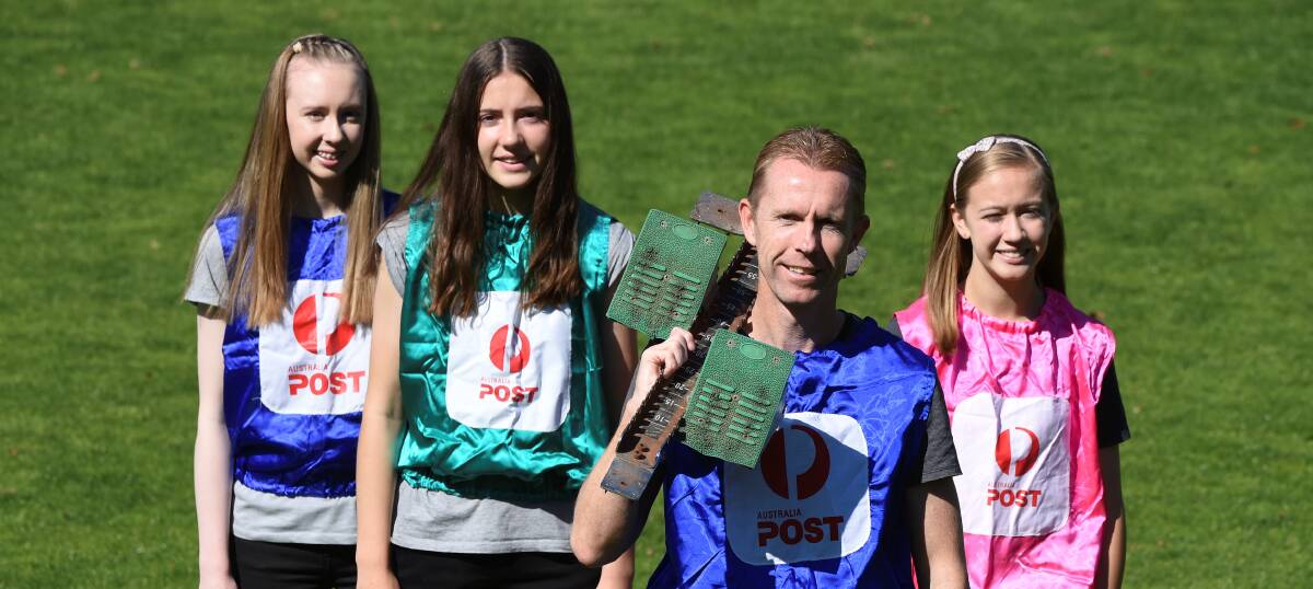 STAWELL COLOURS: Evan King and daughters Maddison, Georgia and Ella in the bibs he wore in his four Stawell Gift finals. Picture: Lachlan Bence