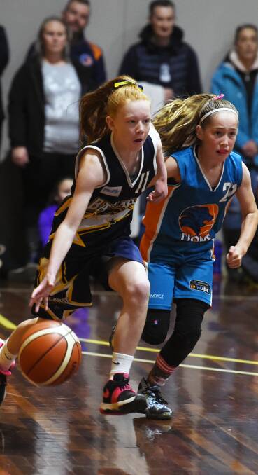 LEADING THE WAY: Meg Stowe transitions down the court ahead of Bacchus Marsh's Charlie McKinnon in a 12A girls' game at the Minerdome. Picture: Kate Healy