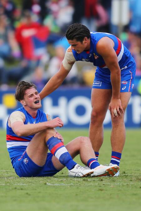 DOWN AND OUT: Jordan Roughead is consoled by Tom Boyd after sustaining a hamstring injury in a pre-season match against Melbourne. Picture: Getty Images