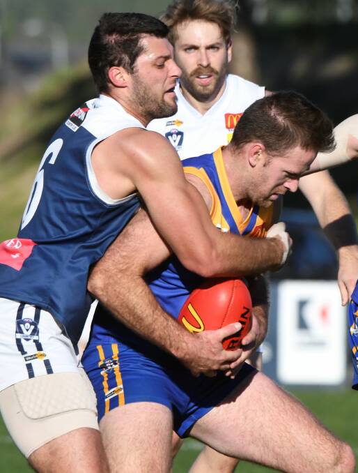 CLASH OF THE TITANS: Melton South ruckman Ben Sortino puts the brakes on Sebastopol big man Tom Petersen at Marty Busch Reserve. Picture: Lachlan Bence 