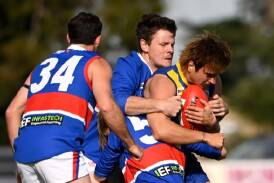 Daylesford's Tom Conroy and Riley White lay a crunching tackle on Learmonth ball magnet Will Green, under the watchful eye of Bulldogs teammate Matt Dean at Learmonth on Saturday. Picture by Adam Trafford.