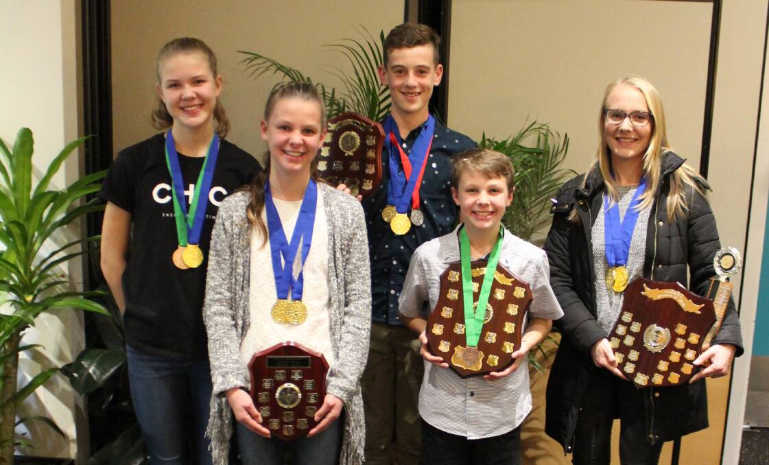 Ballarat Racewalking Club's Jemma and Alanna Peart, Fraser Saunder, Scott Peart and Rachel Tallent with their haul of medals and state team shields.