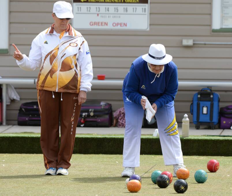ONE UP: City Oval's Janine Roberts signals the state of play, while Joan Dunn examines the head for Sebastopol in midweek division one bowls. Picture: Kate Healy