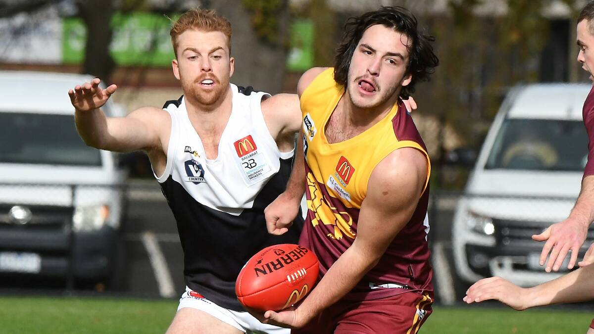 Zac Jenkins (Redan) gets the football away before Mitch Gilbert (North Ballarat City) pounces at the City Oval. Picture: Lachlan Bence