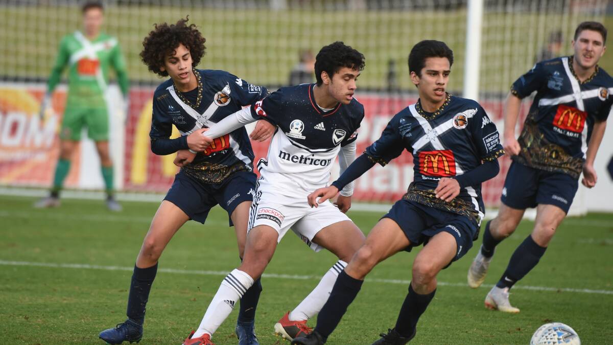 Brandon Lauton is flanked by his brothers Jordan and Leighton in an NPL match between Melbourne Victory and Ballarat City FC in Ballarat this season.