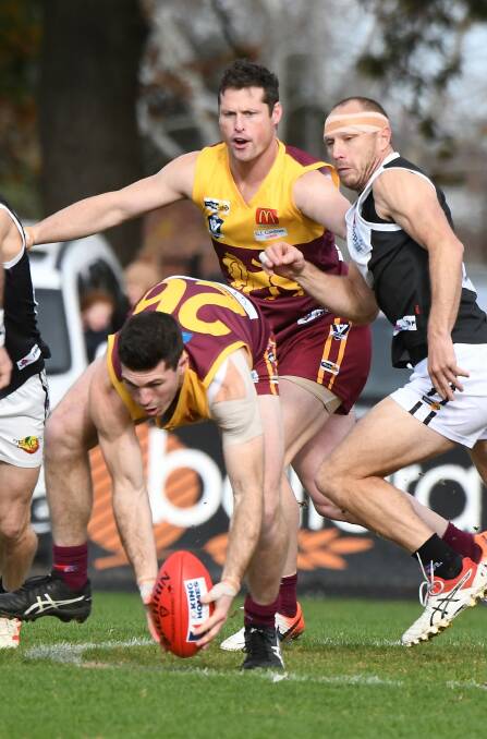 Redan captain Liam Hoy finds the football ahead of teammate Lachie George and North Ballarat City's Jason McNamara at the City Oval. Picture: Lachlan Bence 