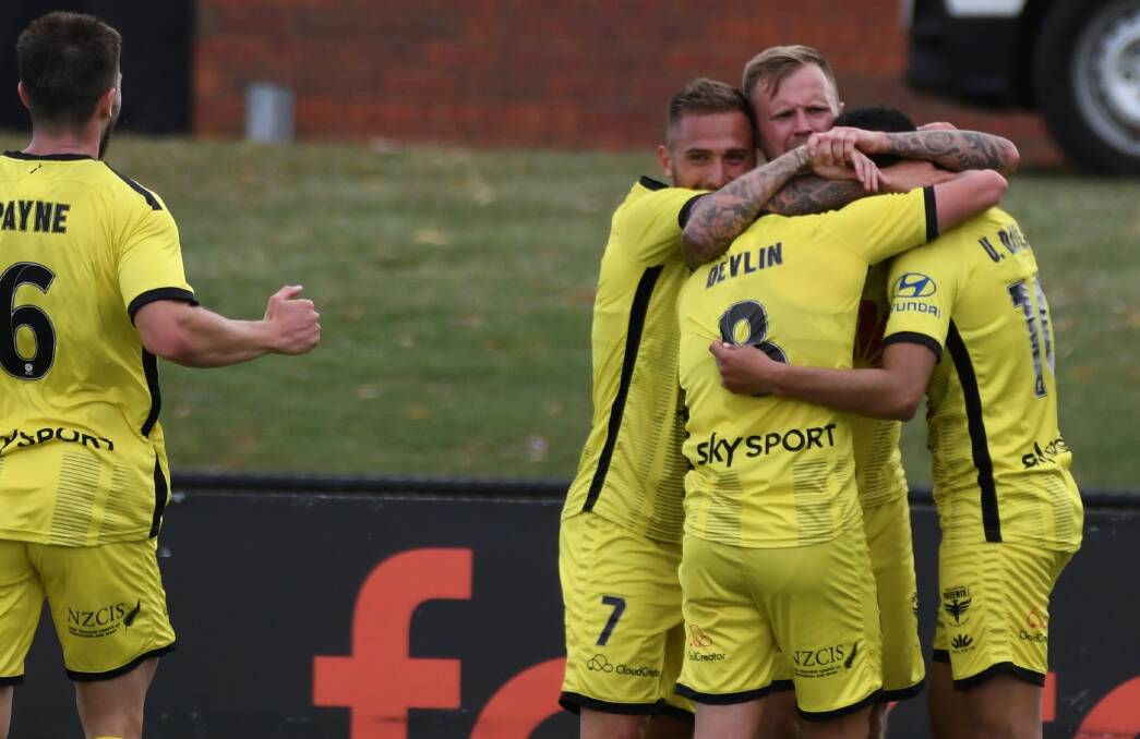 TRIPLE TREAT: Wellington Phoenix players celebrate on of their three goals. Picture: Lachlan Bence
