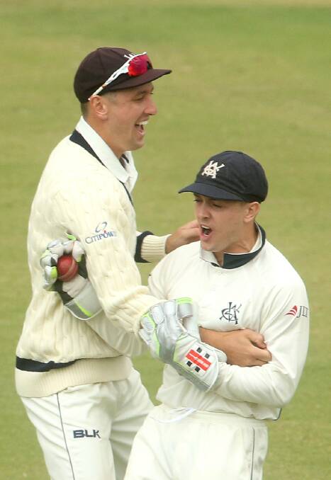 Matt Short and Seb Gotch share their delight at the fall of a wicket.