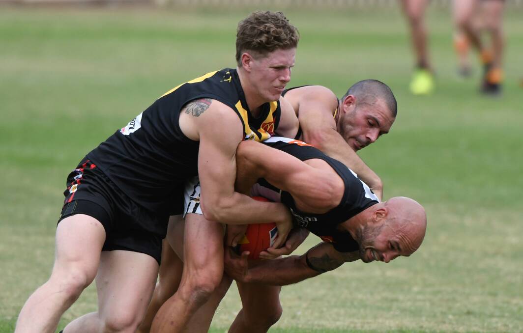 Steve Kennedy is gang-tackled by Bacchus Marsh's Hamish Coulton and Scott Sherlock. Picture: Lachlan Bence
