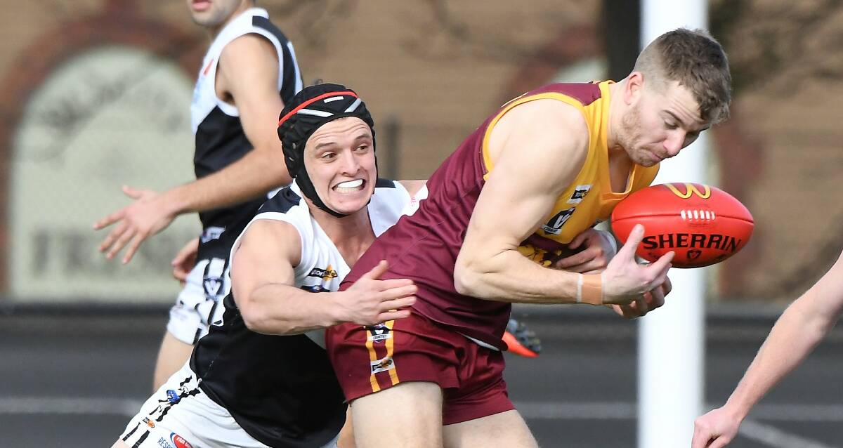 Jacob Short (Redan) gets run down by Sam Bromley-Lynch (North Ballarat City) at the City Oval on Saturday. Picture: Lachlan Bence
