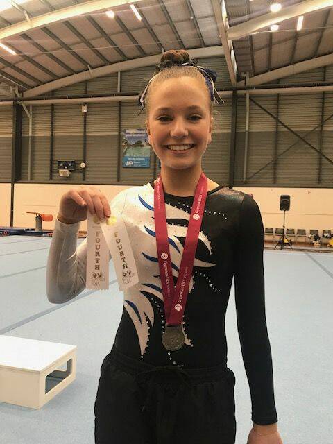 GOOD ROUTINE: Eureka Gymnastics Club's Amelia Everard shows off her ribbons at the Southern Cross Classic. Pictures: Supplied