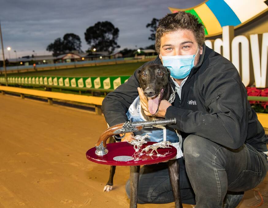 BANG:Tiggerlong Tonk with trainer Correy Grenfell after his Shootout victory. It is the star greyhound's biggest win on the city circuit to date. Picture: Greyhound Racing Victoria