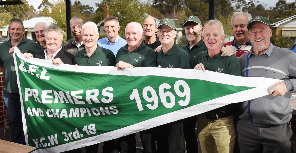 ON SHOW: Members of the 1969 YCW under-18 premiership team  show off their new flag presented to them at a reunion. 