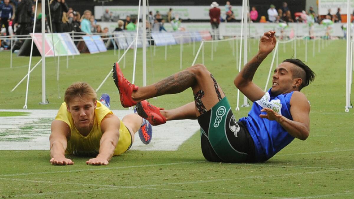CRASH: Isaac Dunmall and Tjimarri Sanderson-Milera take a tumble after crashing to the ground after crossing the line in the Stawell Gift final. Picture: Paul Carracher