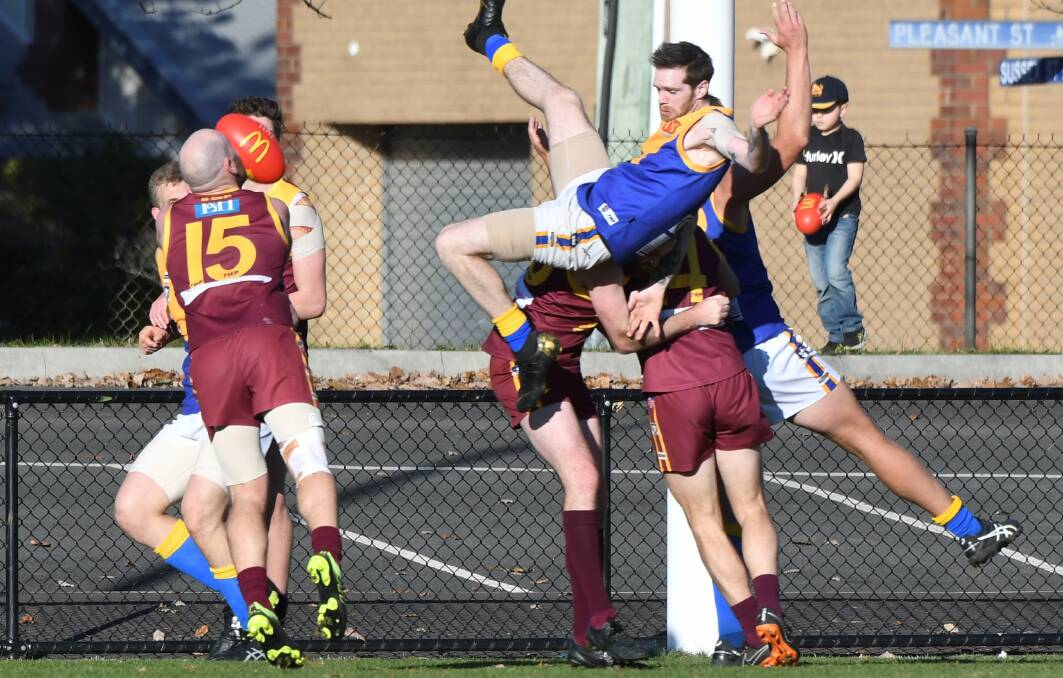 Sebastopol's high flying forward Michael Powell prepares for landing after rising high above the pack at the City Oval, while Redan defender Pat Britt finds the football loanding on his chest. Picture: Lachlan Bence 