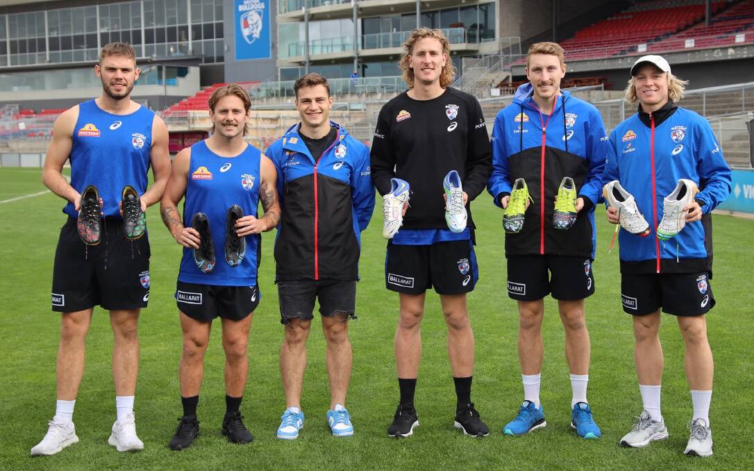 SPECIAL: Cooper Craig-Peters, third from left, with Western Bulldogs players displaying their designs. Picture: Western Bulldogs FC