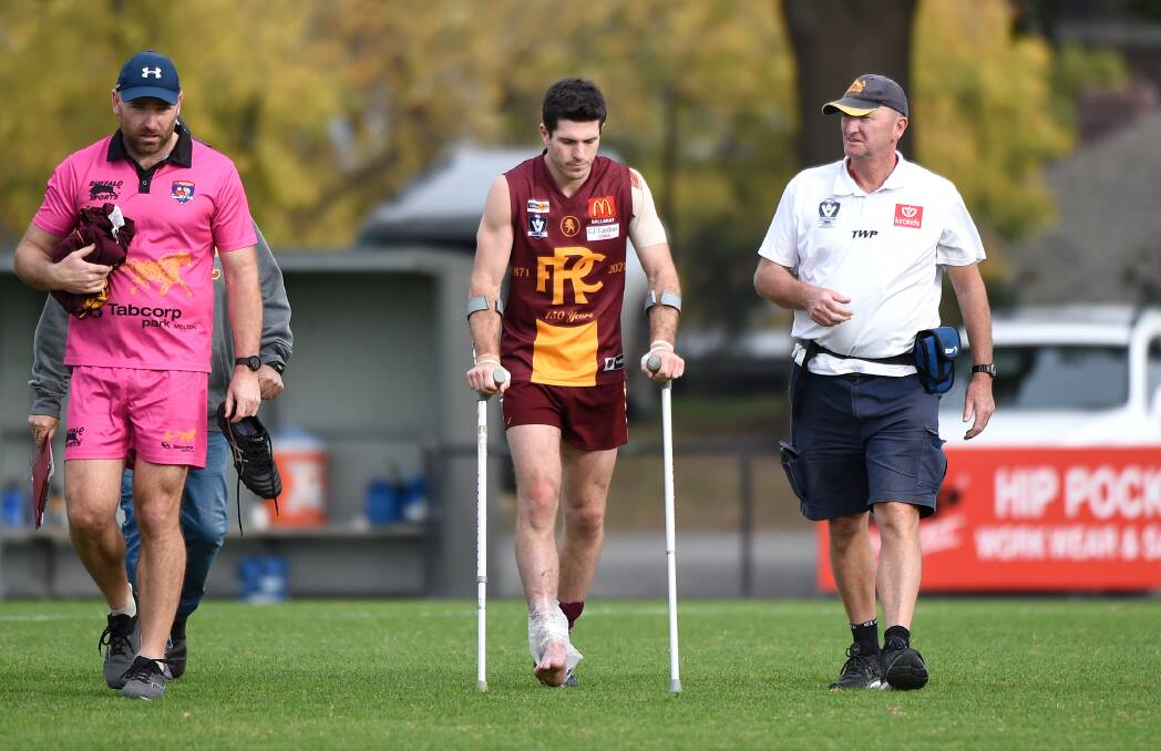 Liam Hoy leaves the field on crutches at half-time of Redan's round three win. Picture: Adam Trafford
