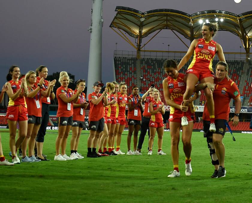 GUN: Sally Riley is chaired off the ground by her Gold Coast teammates. Picture: Getty Images