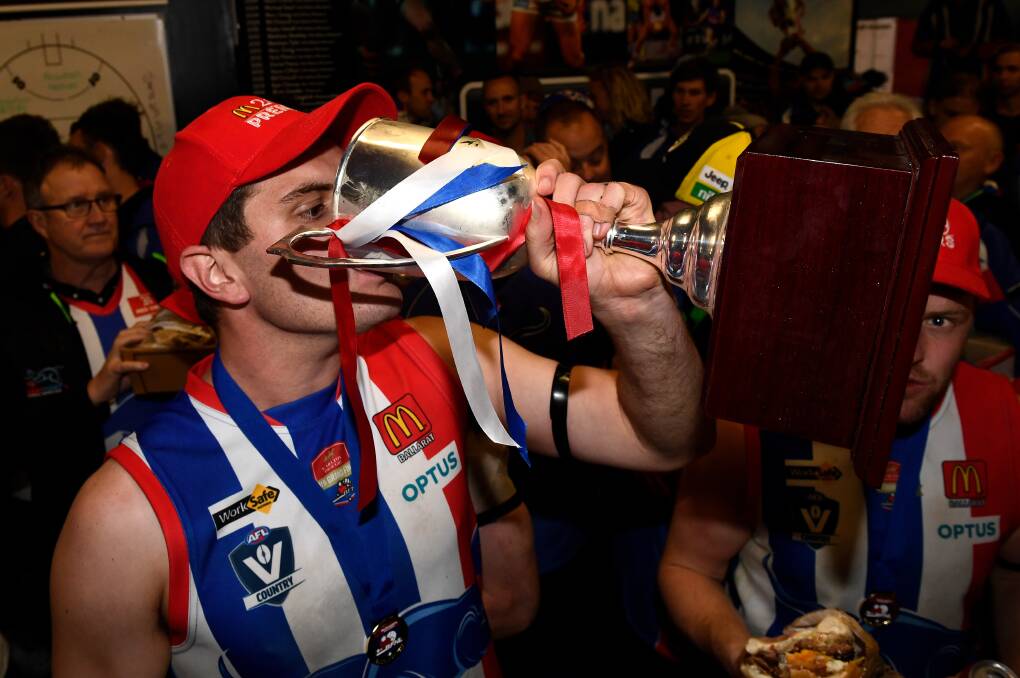 Brad Whittaker drinks from the premiership cup after East Point's 2019 grand final win. Picture: Adam Trafford
