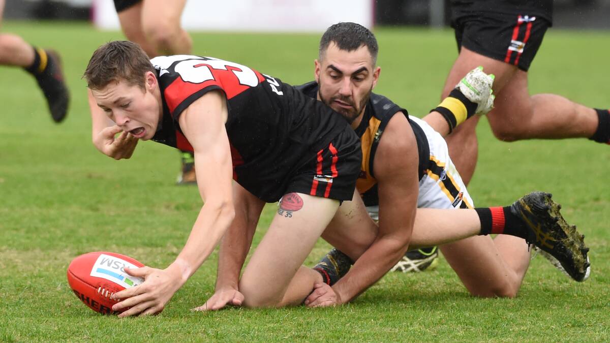 Buninyong's Joshua Sargent is dragged down by Springbank opponent James Thompson. Picture: Kate Healy