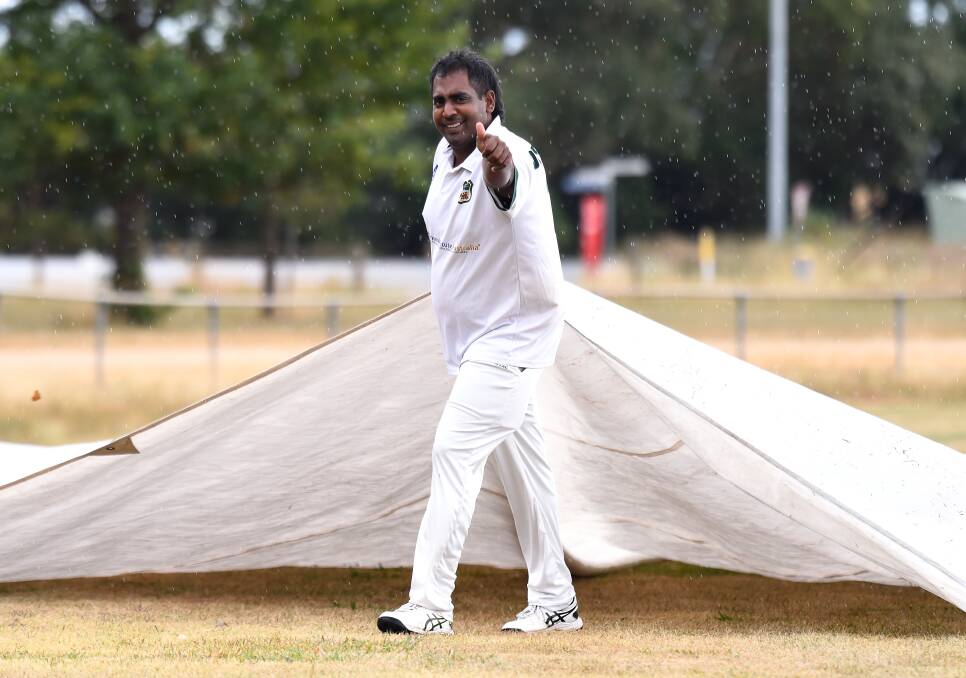Sajith Dissanayaka of Napoleons Sebastopol helps take the covers off the ground during his side's match against East Ballarat. Pictures by Adam Trafford.