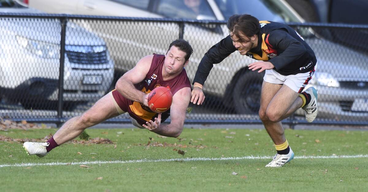 Redan's Lachie George and Bacchus Marsh's Logan Blundell tangle near the boundary line. Picture: Lachlan Bence