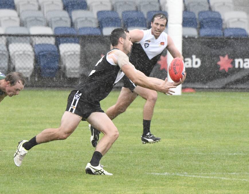 Simon McCartin drags the ball in during a wet North Ballarat practice match. Picture: Adam Trafford