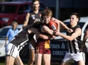 Redan's Rory Gunsser is wrapped up in a tackle against Darley. Picture: Lachlan Bence