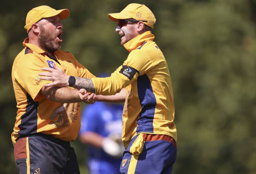 East Ballarat's Adam Eddy and Harli Givvens celebrate a wicket. Picture by Luke Hemer