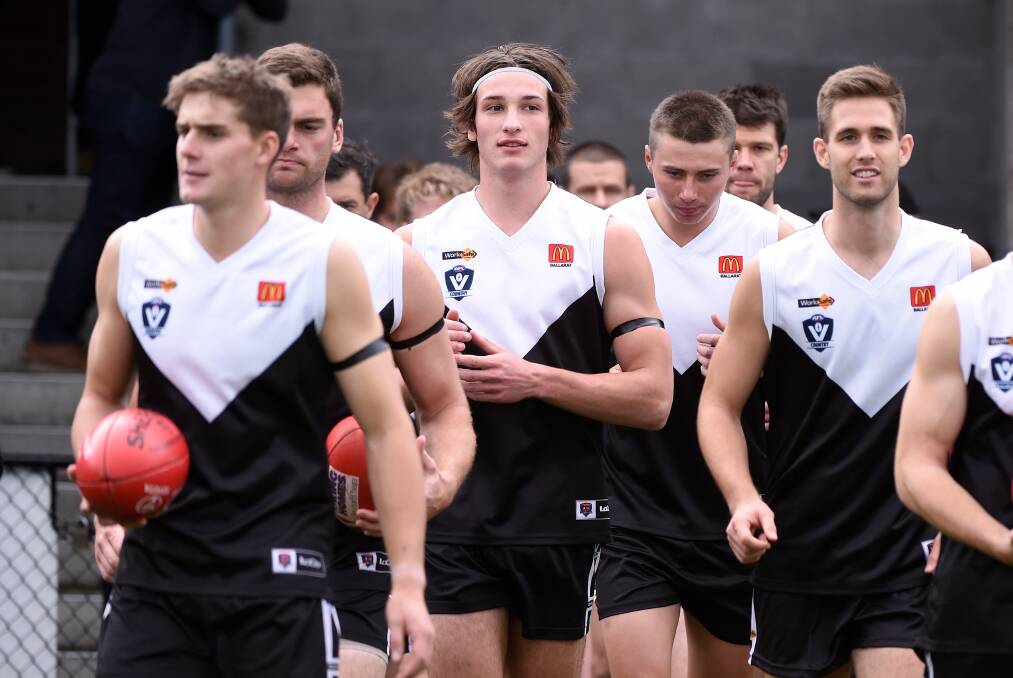 LEADERS: Isaac Lovison, middle, walks out with
North Ballarat earlier this season. Picture: Adam Trafford