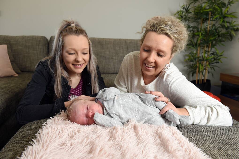 BORN AT HOME: Baby Ashyr enjoys a nap looked over by mother Tahlia Hill and grandmother Chrissy Hill who helped deliver him at home on Thursday morning. PICTURE: Kate Healy 