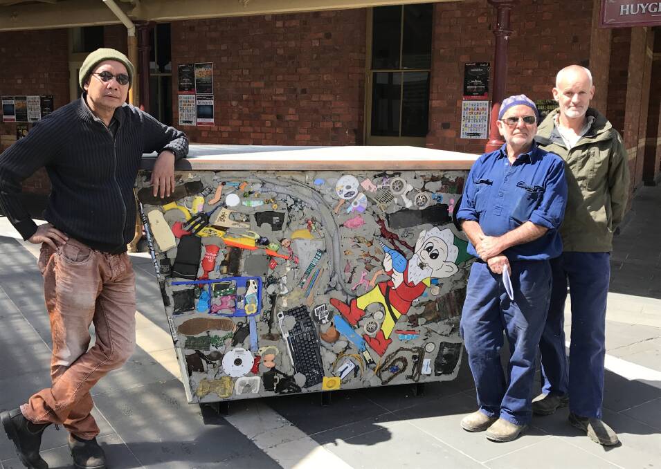 SKIP ART: Local artists Diokno Pasilan, Pete Gregg and Scott Fredericks with their concrete and rubbish covered skip bin. Picture: Michelle Smith
