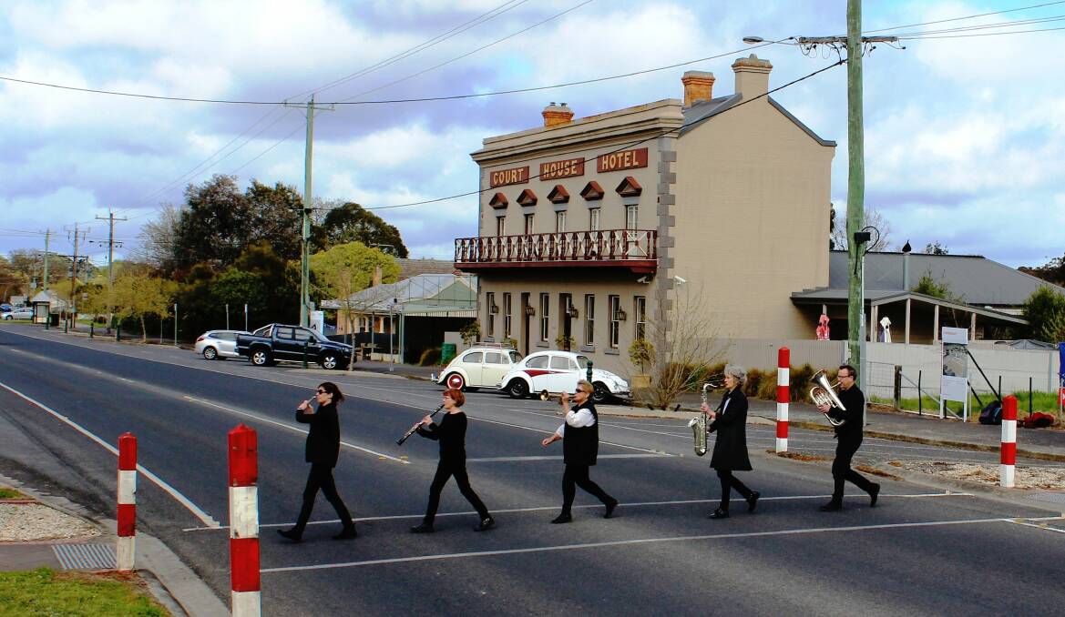 FIESTA: Members of the Haddon Concert Band cross the road Beatles-style in front of two VW Beatles from the Ballarat Volkswagon Club to mark the first Smythesdale Community Arts and Music Fiesta. Picture: Barry Wemyss