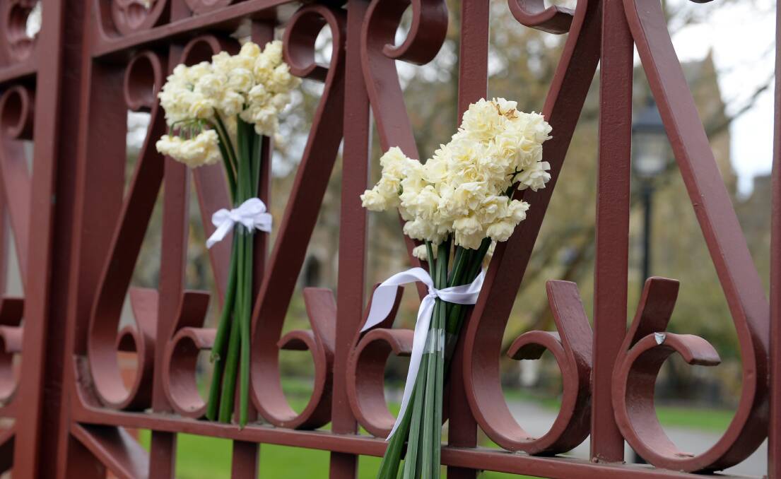 Jonquils tied to the front fence of Loreto College the day after the bus crash. Picture by Kate Healy