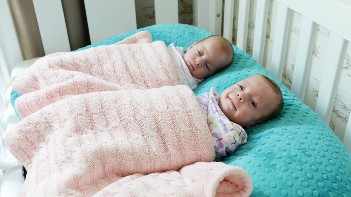 SMILES: Alexa (front) gives a cheeky grin while sister Emmie dozes after a nap. Picture: Kate Healy 
