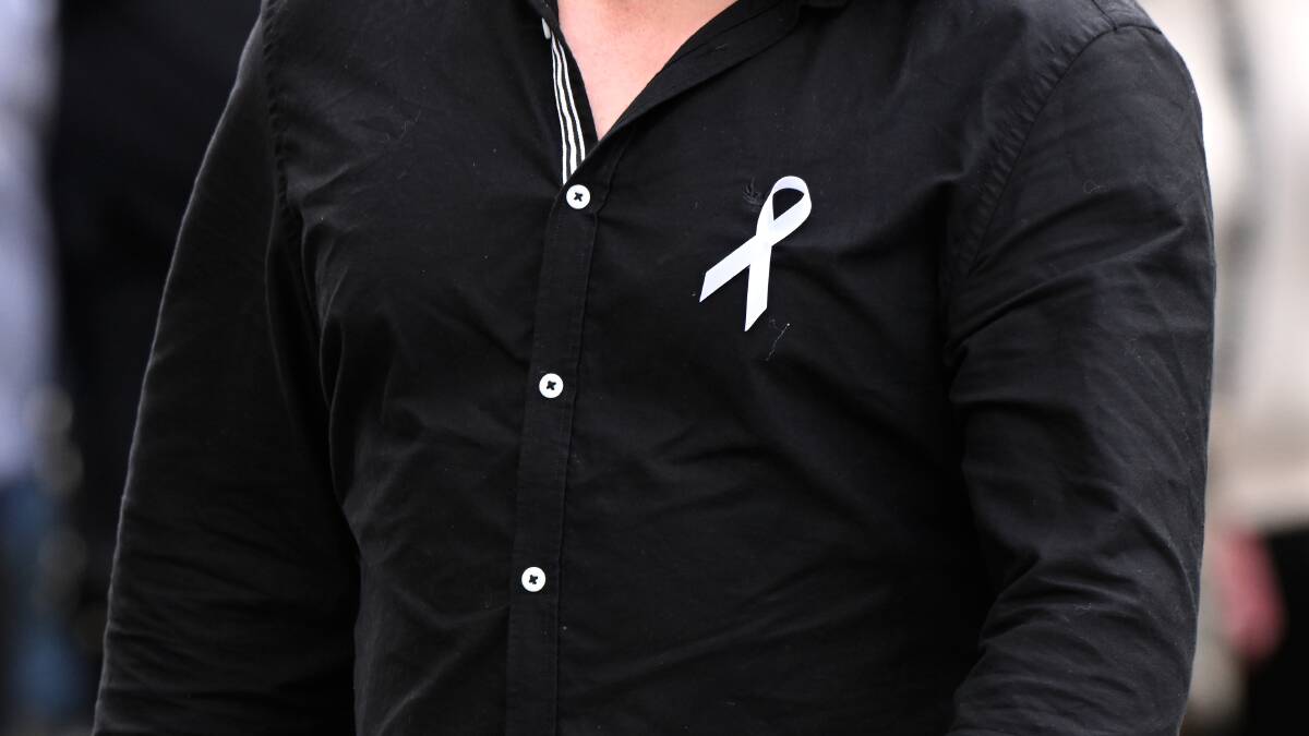 Many of those gathered at the funeral wore white ribbons to support the White Ribbon Foundation. Picture by Adam Trafford