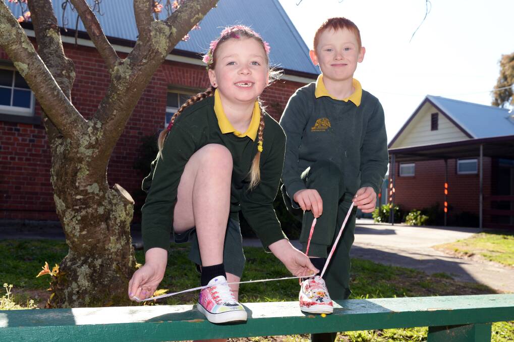 SNEAKERS: Lacey and Ryder with the shoes they decorated for Walk to School month. Picture: Kate Healy
