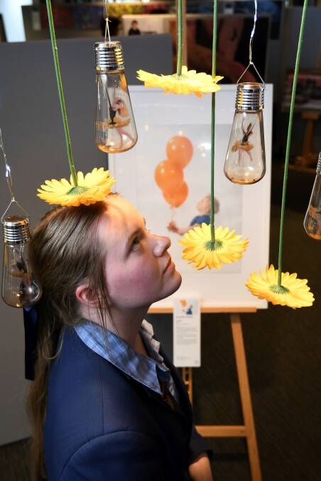 CONTEMPLATION: Jacqueline Holding with her artworks on display at Damascus College Year 12 Visual Art Exhibition, which includes works in media, photography, art, visual communication design and product design. Picture: Lachlan Bence