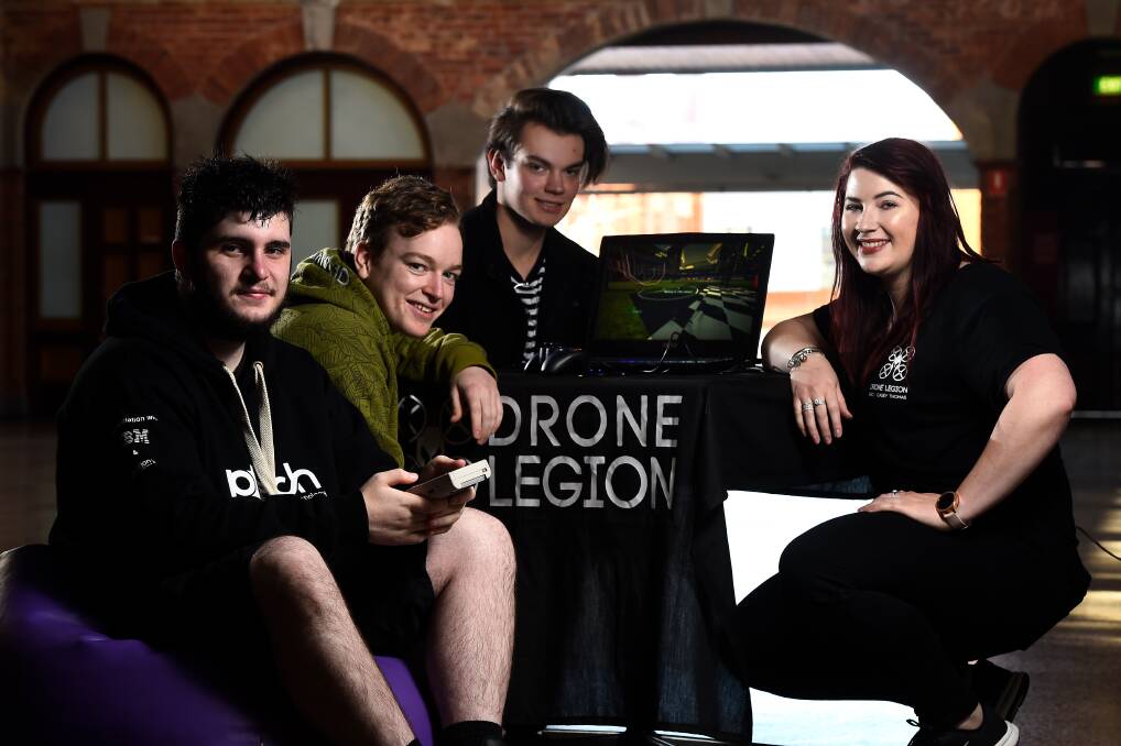 GAME ON: Drone Legion developer Casey Thomas of Dark Shadow Studios (right) with players Kyle Grant, Oscar De Vries and Cameron Betts at the launch of the Winteractive Arcade. Picture: Adam Trafford