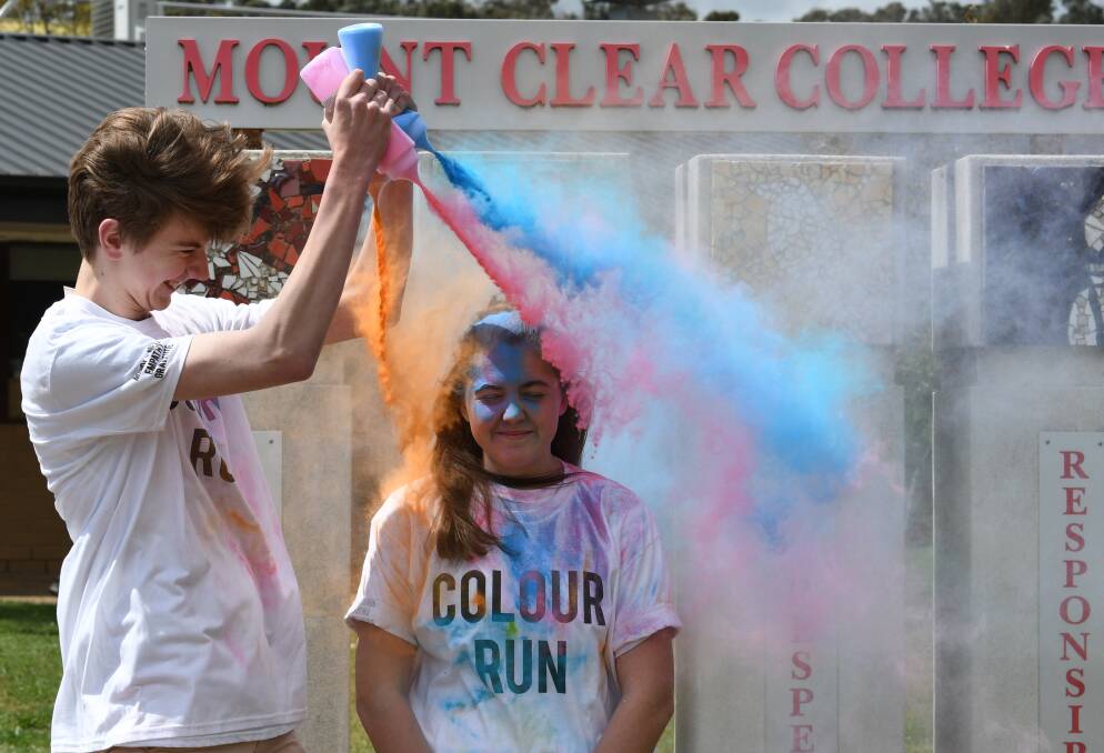 RESILIENT: Aiden Edwards douses Mikela Howard-Bush with a cloud of colour for Mount Clear College's Colour Run, held to promote resilience. Picture: Lachlan Bence.