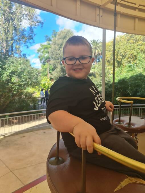 MERRY-GO-ROUND: Caleb enjoys an outing with family but cannot walk for more than five minutes because of intense pain in his legs and feet. Picture: supplied