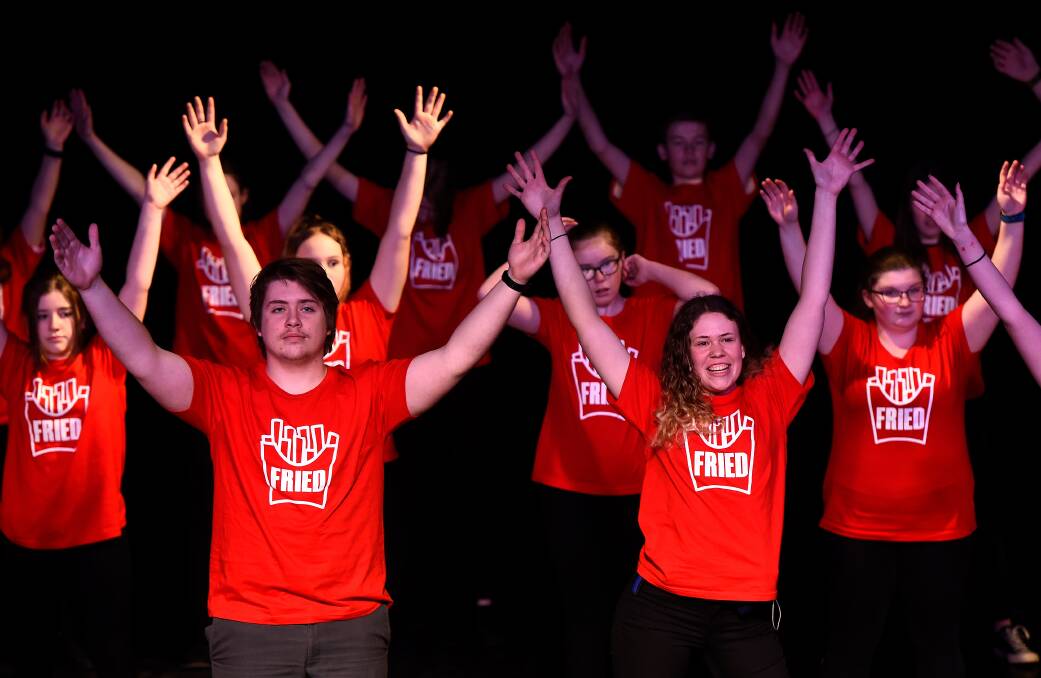 HANDS UP: Year 12 students Jacob Ryan and Karli Drew lead the cast in a musical number during Fried. Picture: Adam Trafford
