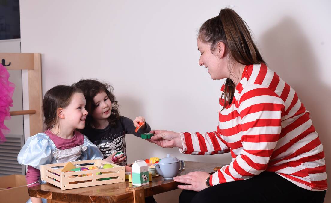 CARE: Brady Bunch Early Learning centre assistant director Emma Poloski has a tea party with Zoe and Ava. Picture: Adam Trafford