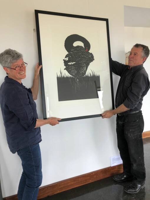 DISPLAY: Vida Pearson and Fred Ross hang a linocut called Grace at Lucy McEachern gallery at Wingeel.
