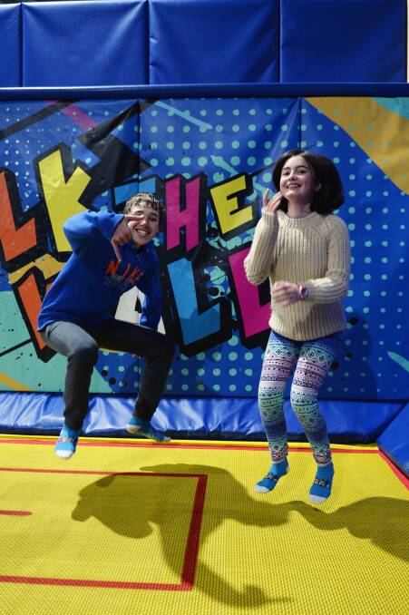 BOUNCE: Patterson Bridges, 14, and Jasmine Nanscawen, 14, jump off some energy at Xtreme Bounce as part of the Pinarc school holiday program. Picture: Kate Healy