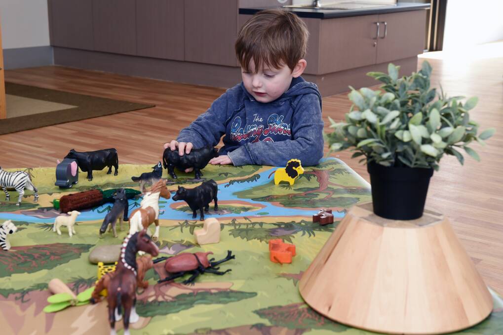 PLAYTIME: Carter, 3, has fun with the animals on the play table at Sesame Kids.