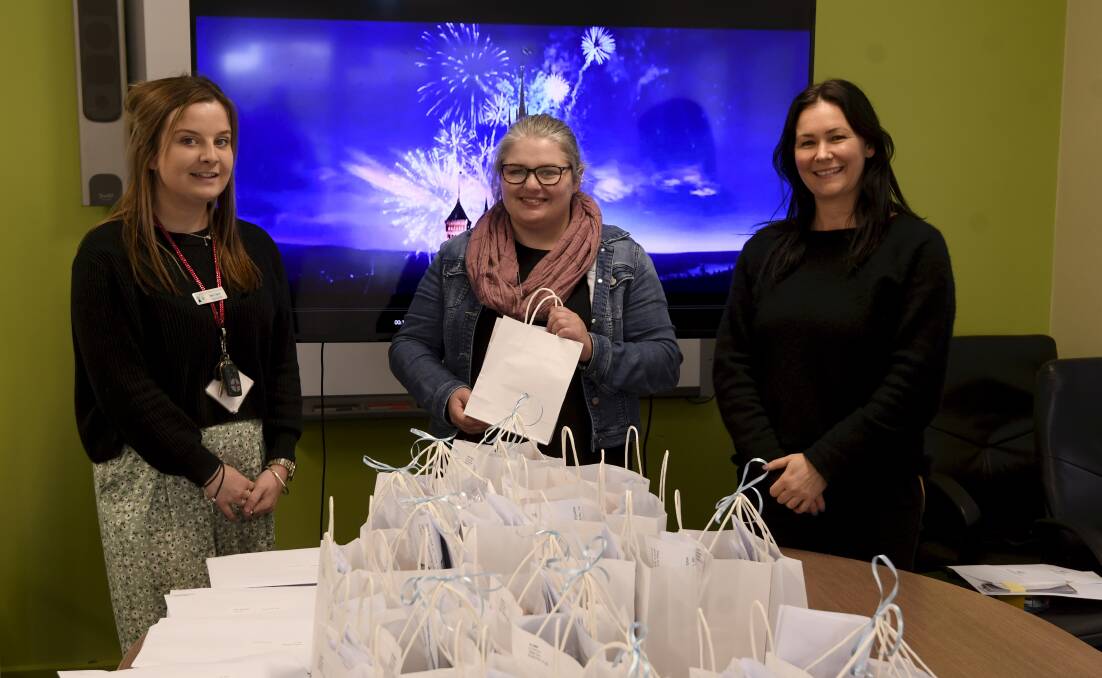 PACKING: Mount Pleasant Primary staff Bek Taylor, Meg Bond, and Anna Johnson prepare movie night packs to deliver to the school's 84 families. Picture: Lachlan Bence